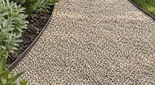 A curved gravel path bordered by a garden bed and metal edging.