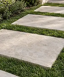 Rectangular stone pavers set into a lawn.