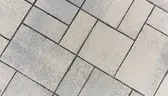 Light gray rectangular paving stones laid in a geometric herringbone pattern.