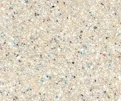 Close-up view of a beige speckled countertop surface with small flecks of white, black, and blue.