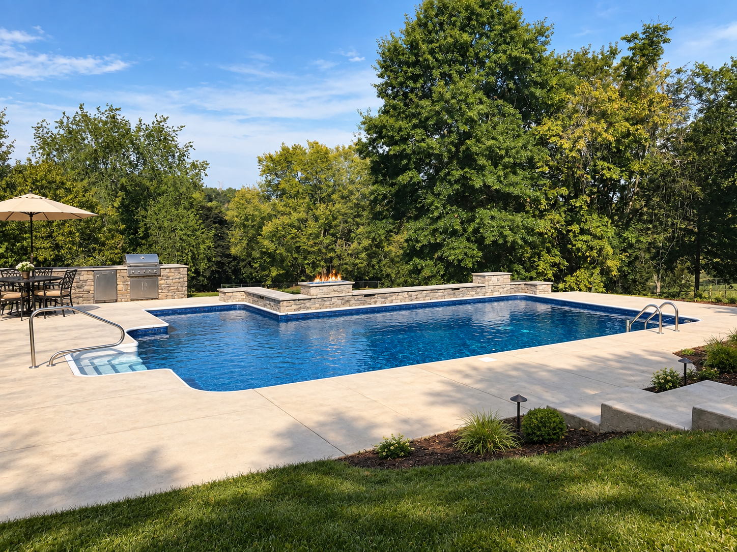 Inground pool with a stone fire feature, outdoor kitchen, and patio