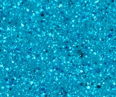 Close-up of a bright blue composite surface with multi-toned granular flecks.