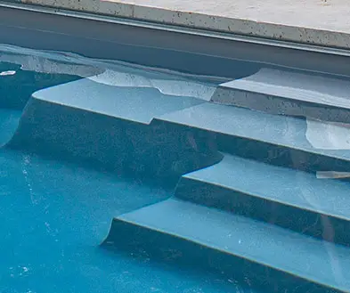 Wide, multi-level steps built into a blue swimming pool.